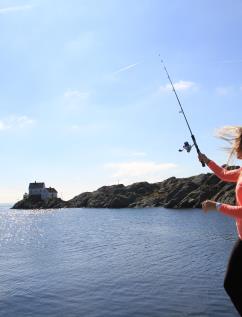 Jente med fiskestang og utsikt til Vikeholmen fyr