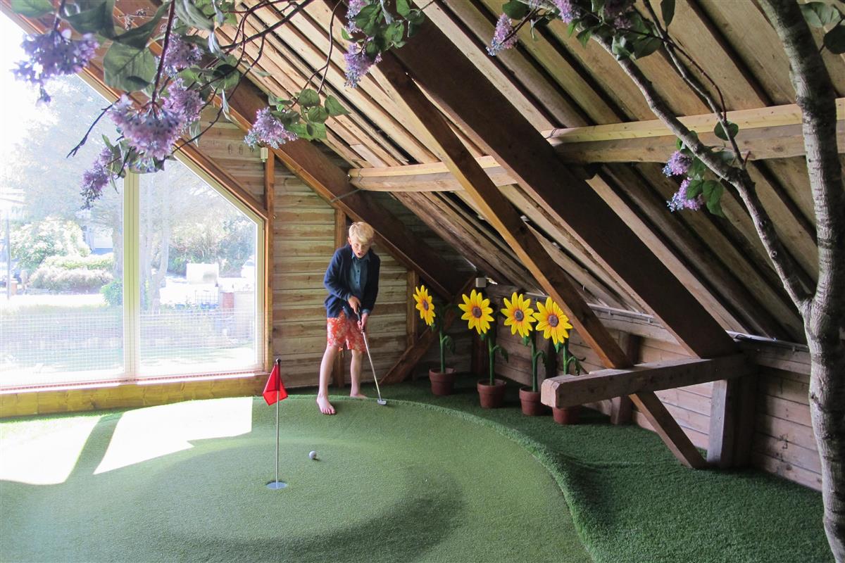 Gutt som spiller minigolf inne på låve - Click for large image