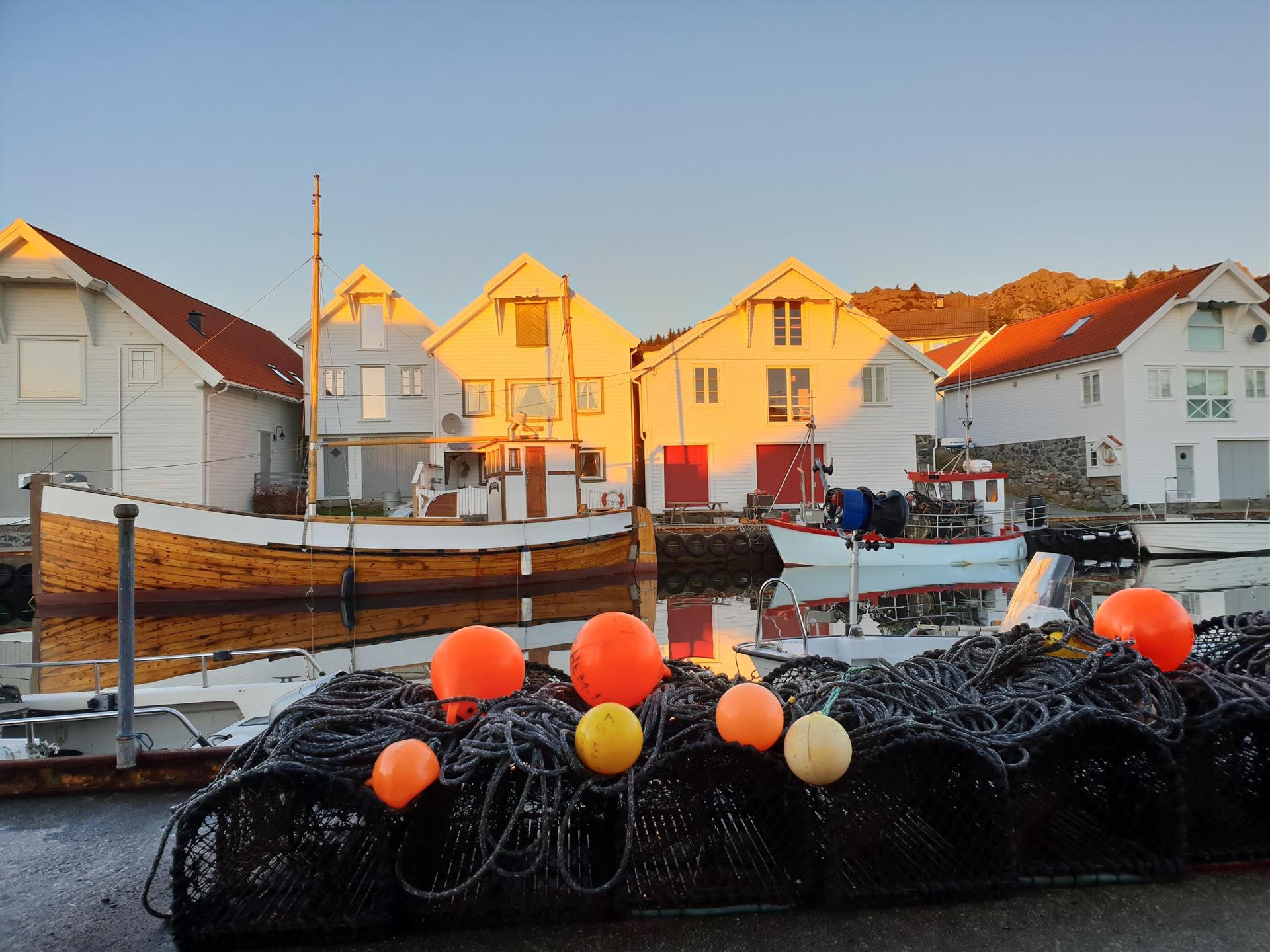 Garn og blåser, båt og sjøhus i rekke på Sandve havn